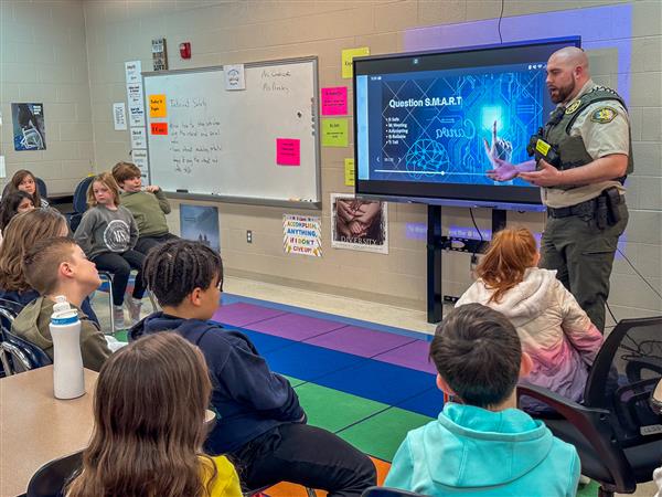 police officer talking to class of students